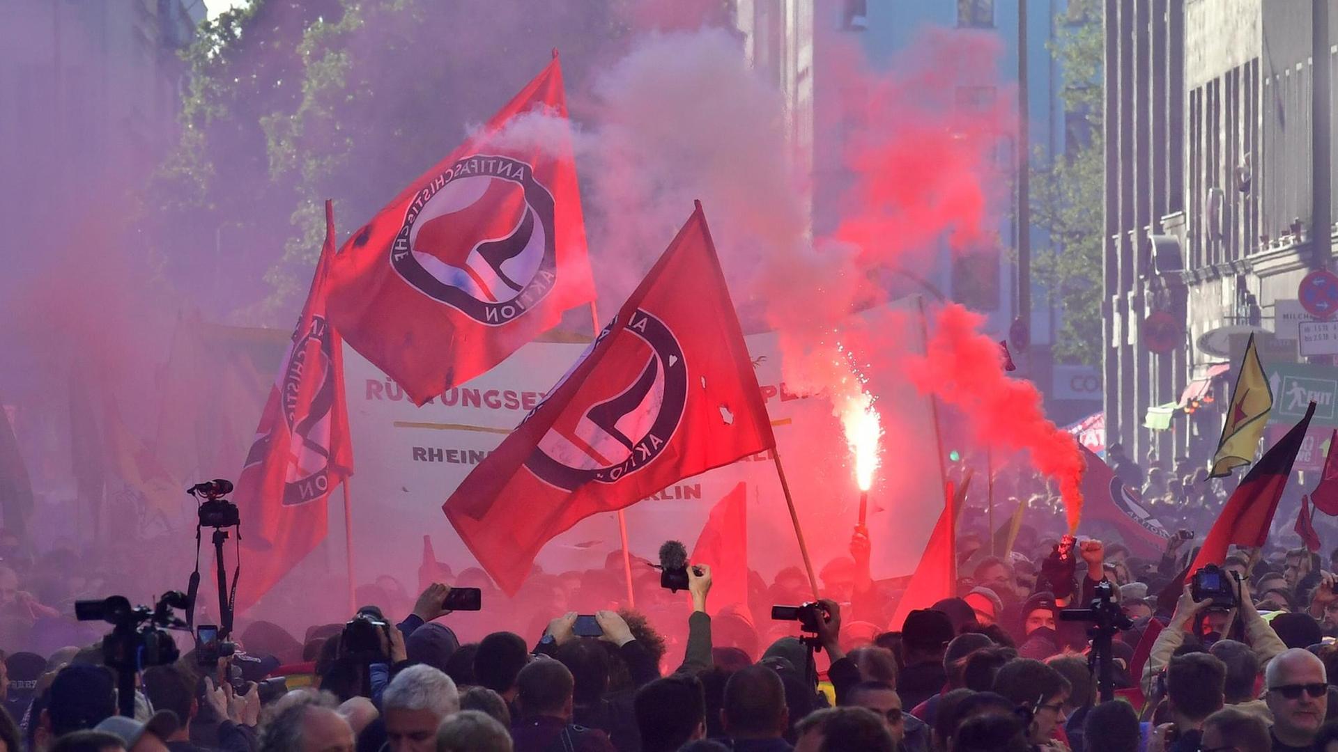 Symbolbild: Demonstration mit roten Fahnen der Antifaschistischen Aktion und Pyrotechnik; die Aufnahme zeigt nicht den Göttinger Einsatz